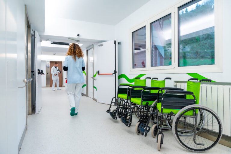 Back of nurse walking along a corridor of an hospital