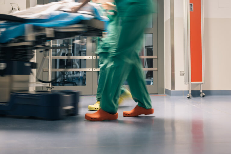 Surgeons in Motion, legs and feet of surgeons in green scrubs and colorful shoes as they walk through a hospital